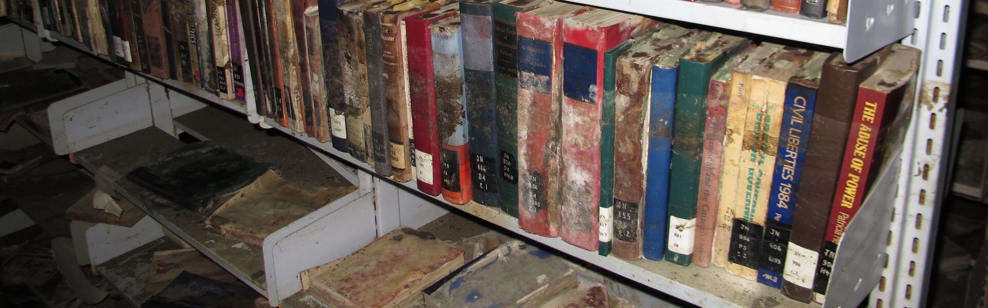 Durchweichte Bücher in einem Archivregal